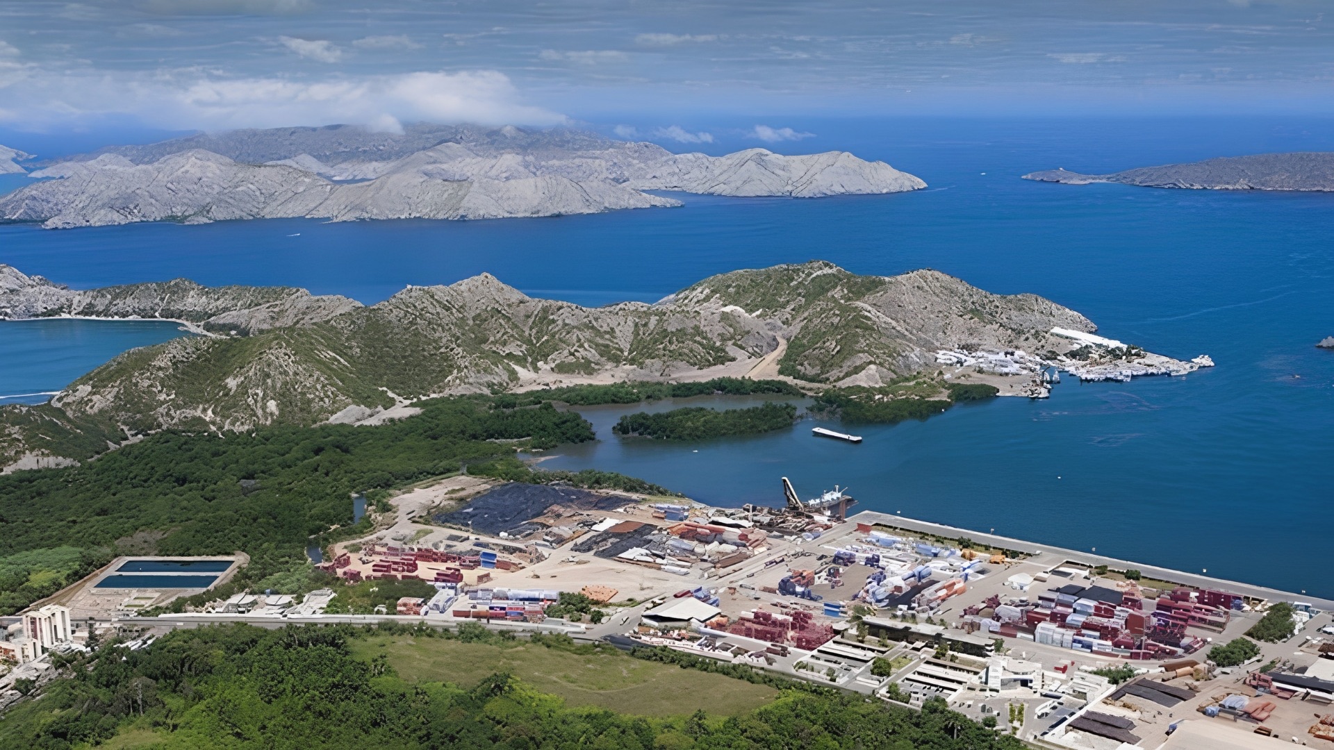 Vista aérea panorámica de la bahía de Guanta con montañas e instalaciones portuarias