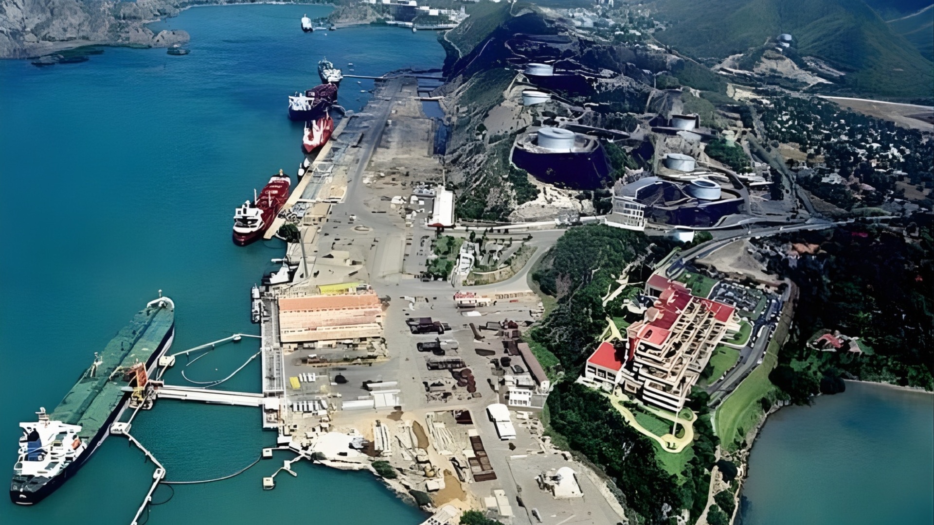 Vista aérea de instalaciones industriales y muelle junto a la bahía