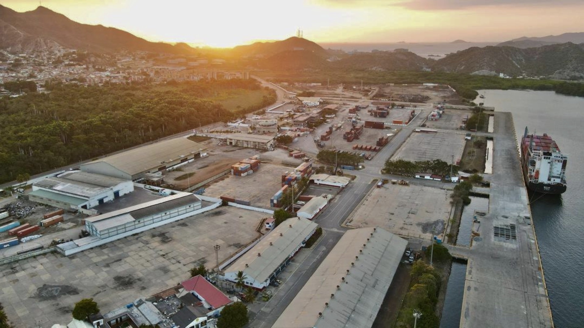 Vista aérea de las instalaciones del Puerto de Guanta al atardecer, con buque atracado en el muelle
